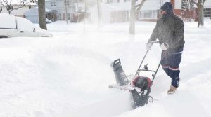 person clearing driveway of snow